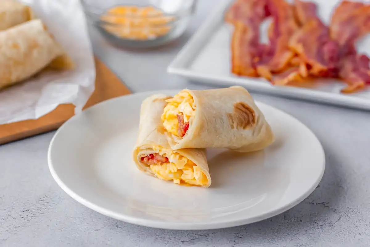 Horizontal view of burrito sliced in half stacked on plate.