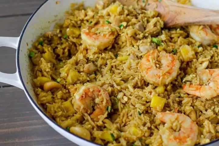 Fried Rice in a large white skillet with a wooden spatula.