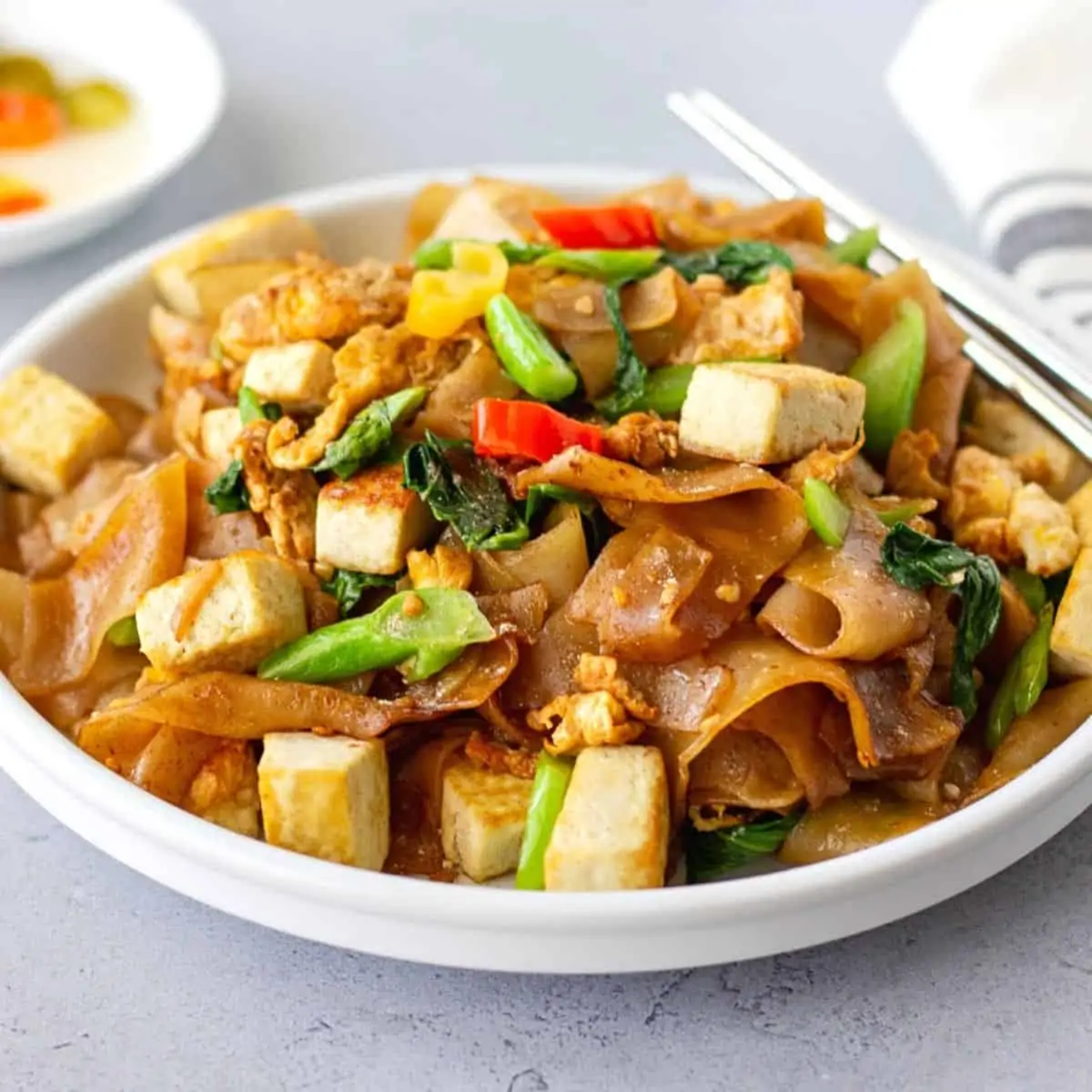 Feature image of pad see ew on a white plate with silver chopsticks.