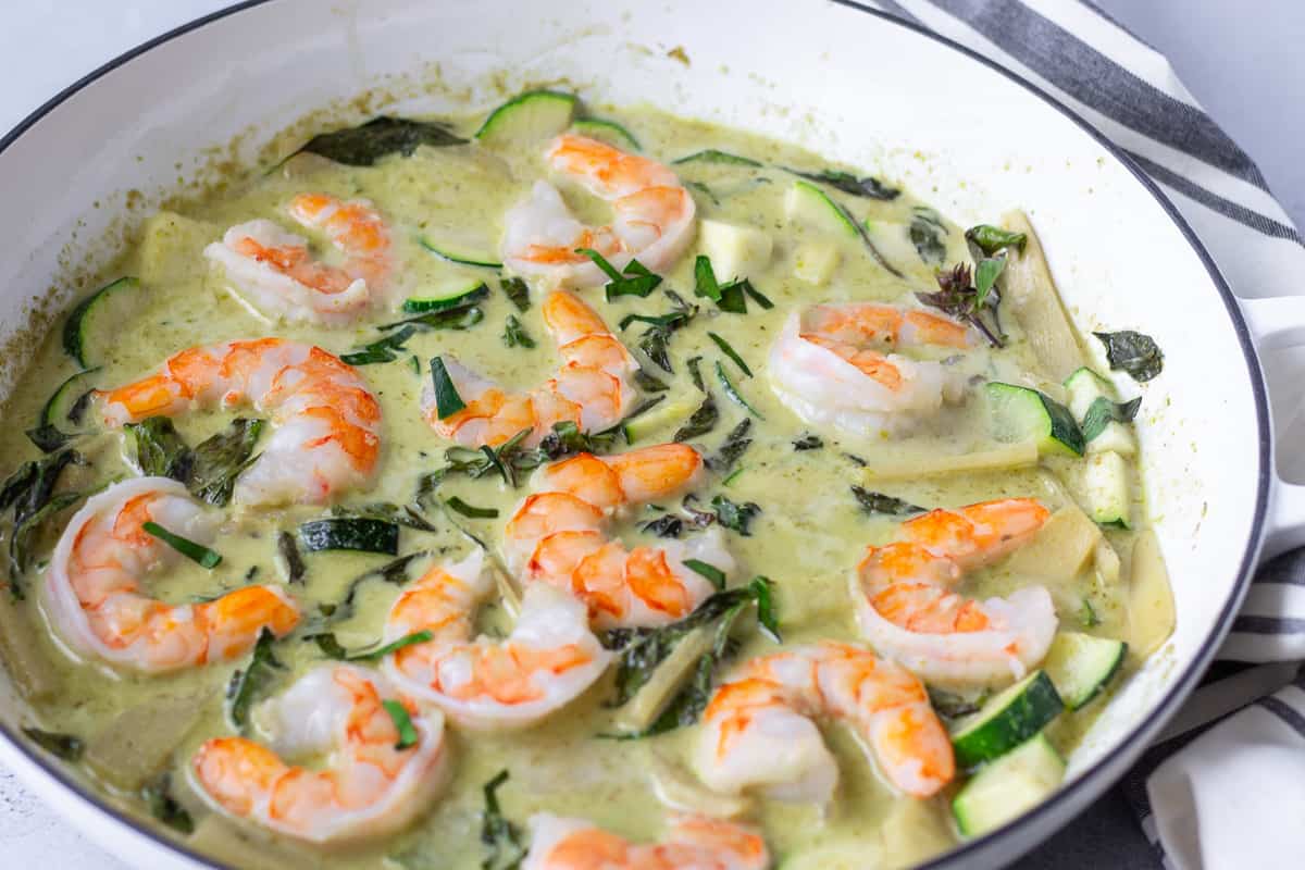 Finished curry dish in a large white skillet.