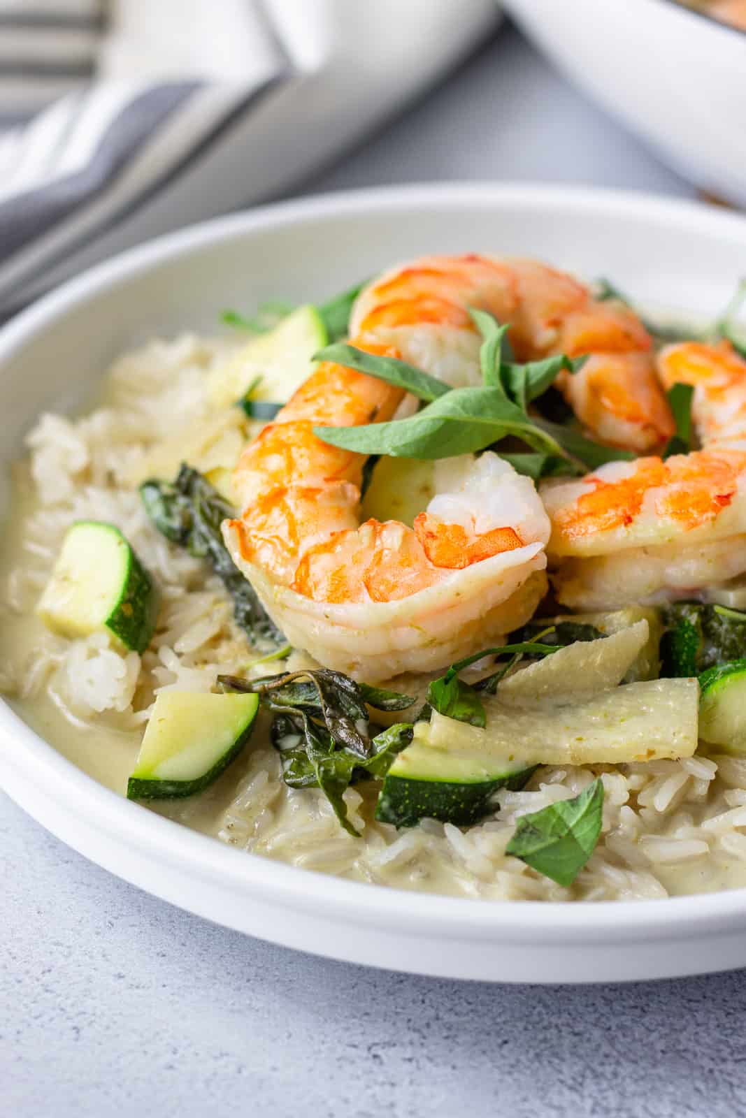 Up close view of shrimp on plate of green curry.