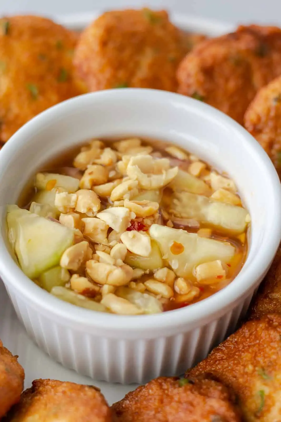 Up close view of sweet chili dipping sauce topped with peanuts.