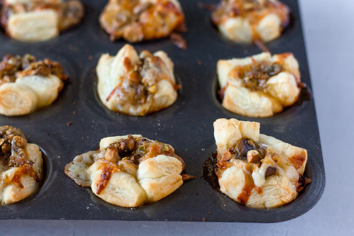 Baked puff pastry bites in a a mini muffin tin.