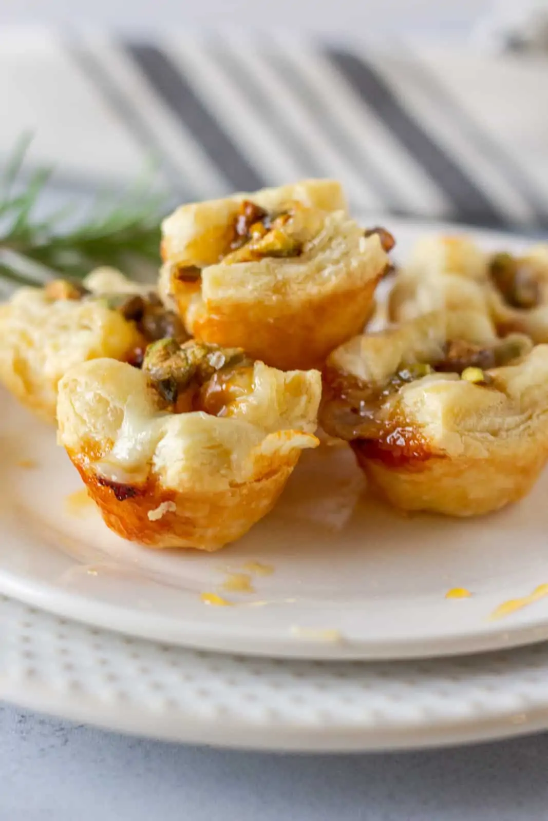 Baked puff pastry bites on a plate with honey drizzled.