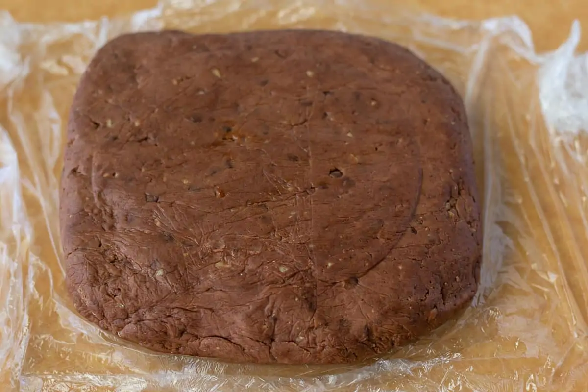 Disc of dough on plastic wrap.
