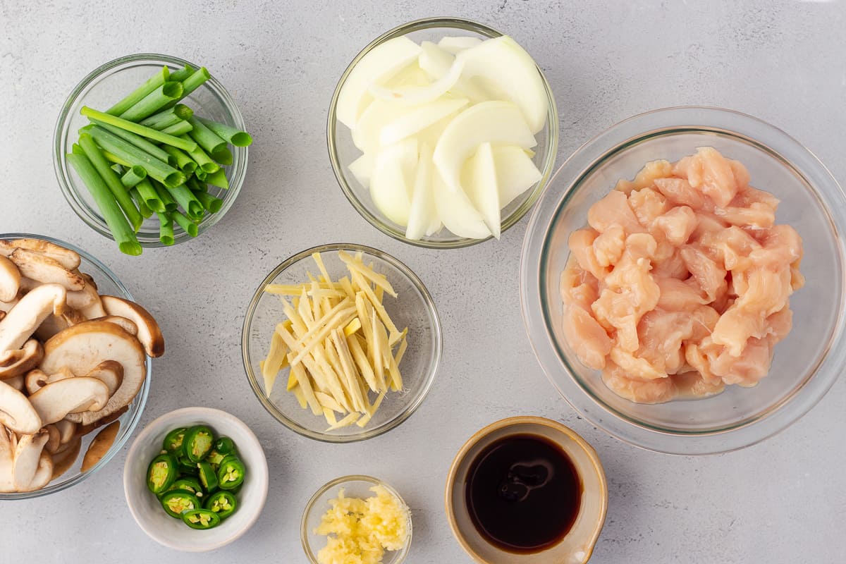 Chicken, onions, ginger, mushrooms, soy sauce, and sliced jalapenos in separate bowls.