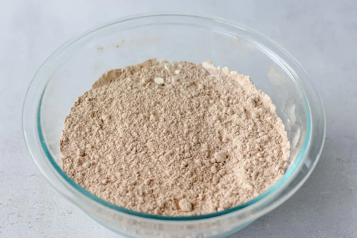 Glass bowl with flour and cocoa powder mixed together.