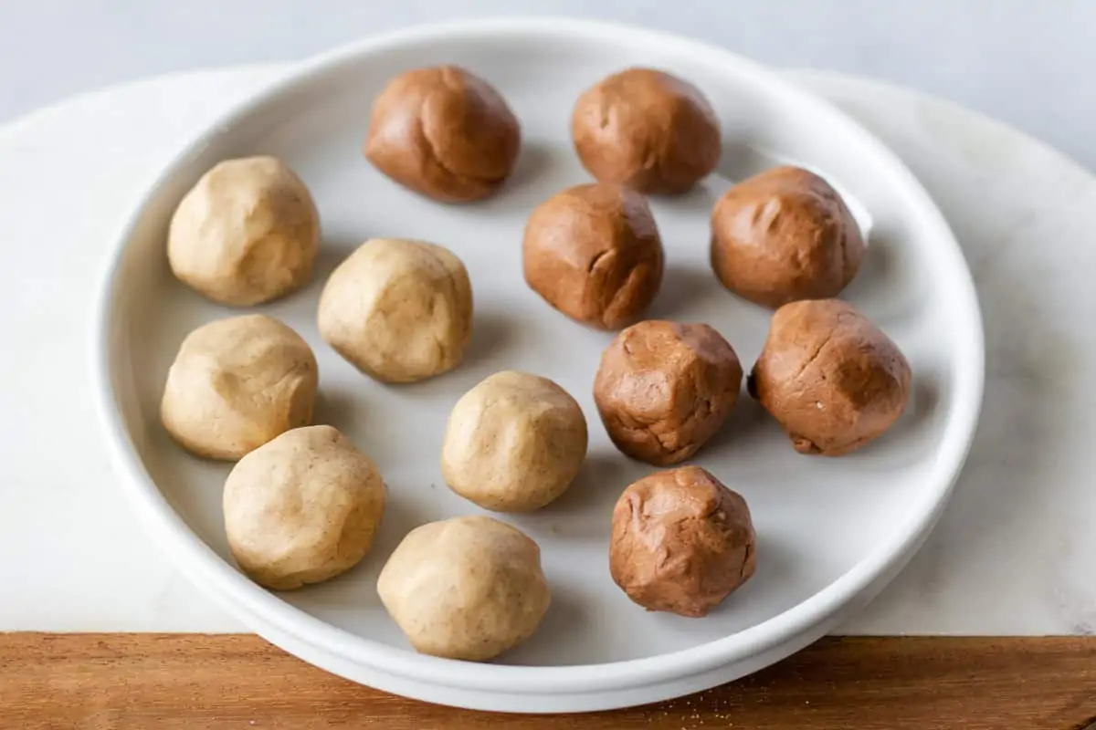 12 round balls of sugar topping on a white plate.
