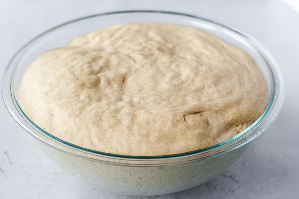 Proofed dough in a glass bowl.