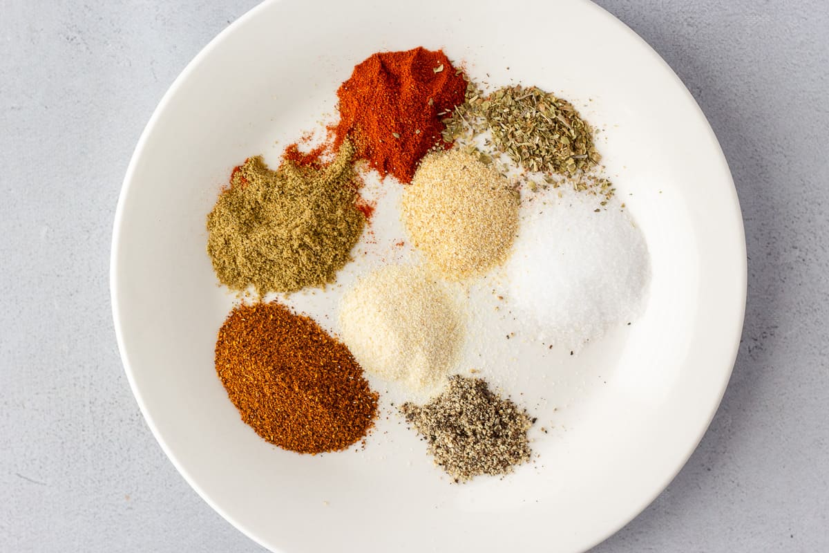 Round white plate with spices and seasonings.