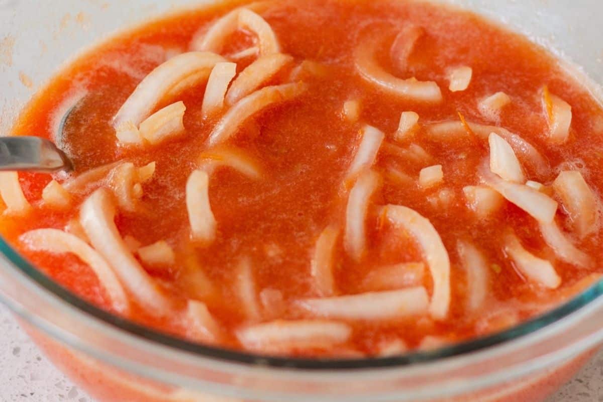 Glass bowl with onions and tomato sauce.