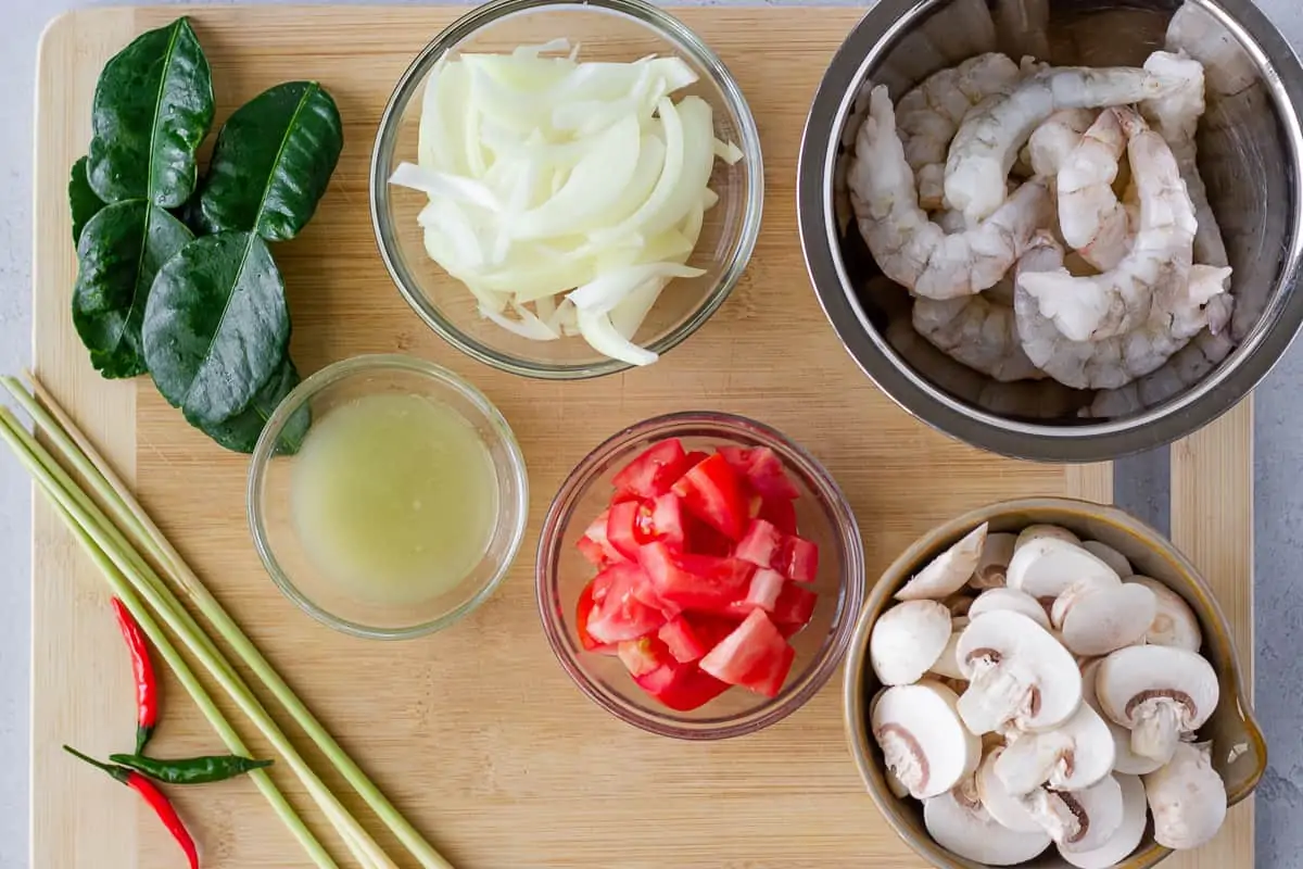 Ingredients in individual bowls on a wood cutting board.