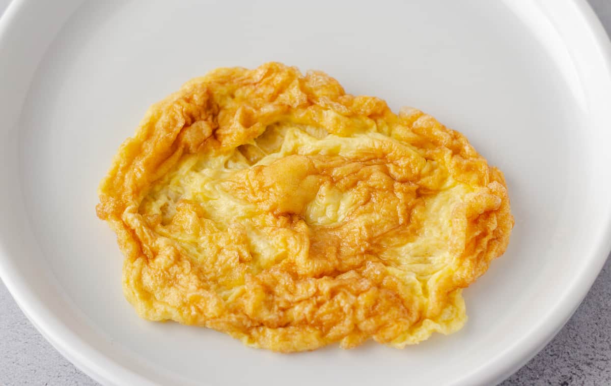Fried egg omelet on a white plate.