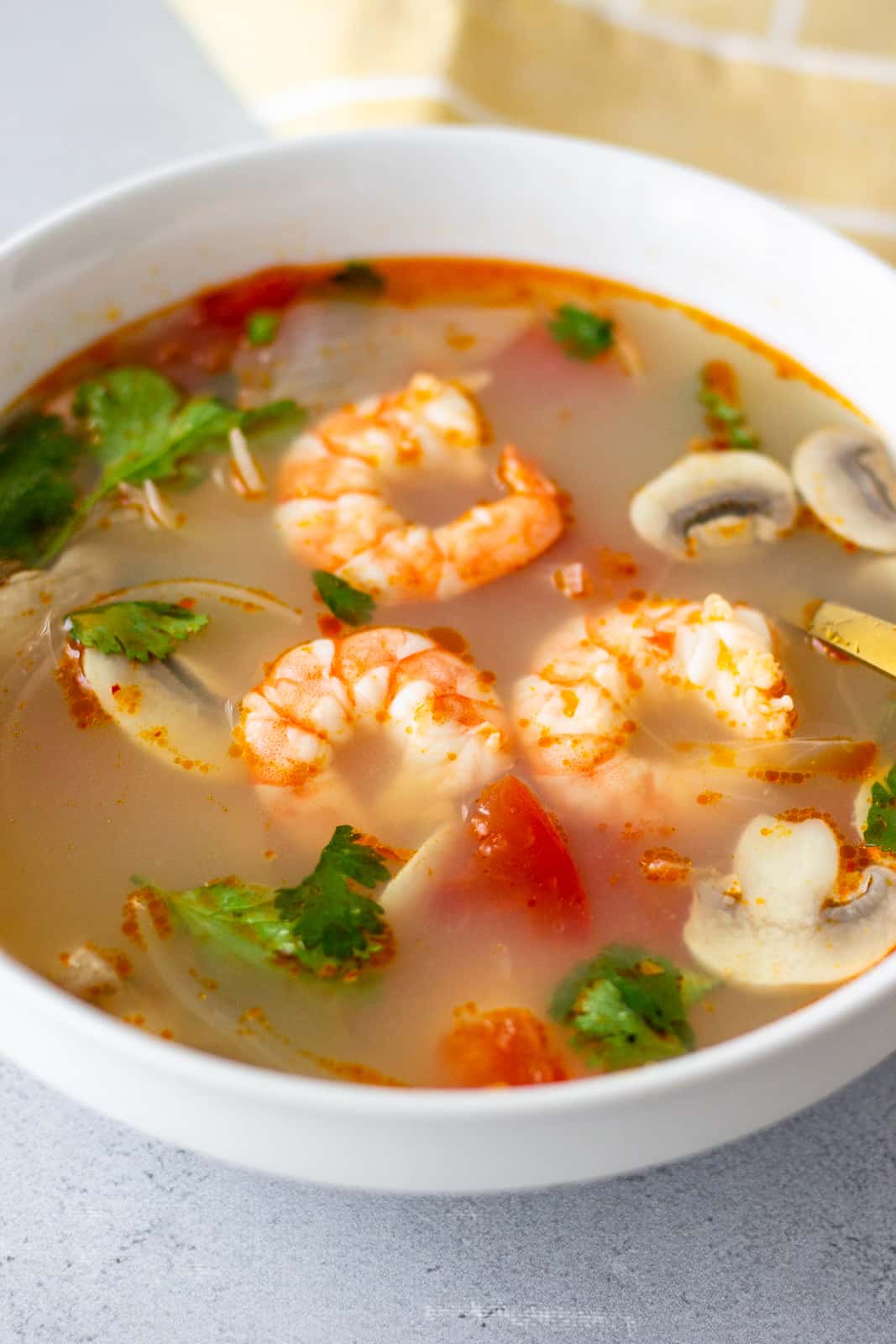 Shrimp soup in a white bowl garnished with cilantro.