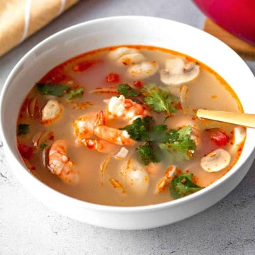 Shrimp soup in a white bowl.