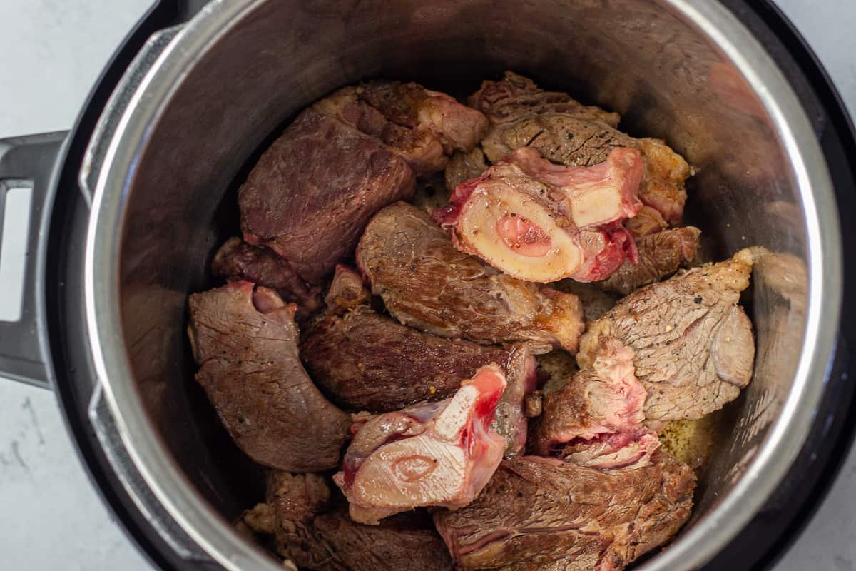 Seared beef pieces inside instant pot.