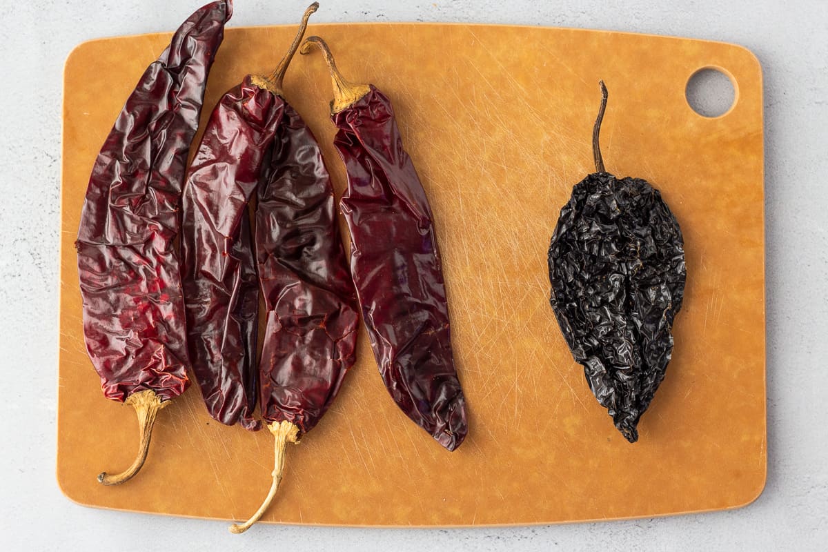 5 Dried peppers on a cutting board.
