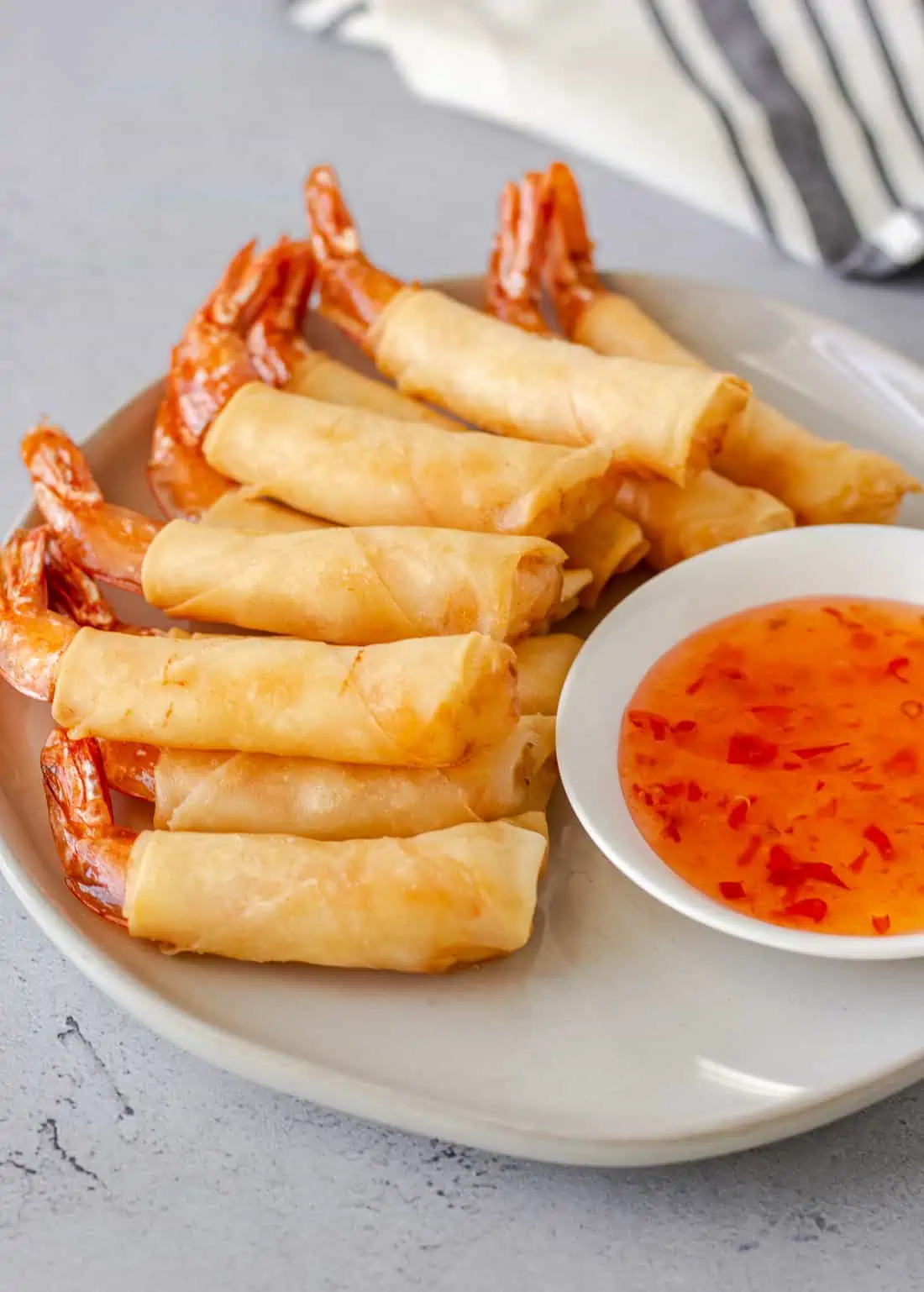 Shrimp in a blanket stacked on a plate.
