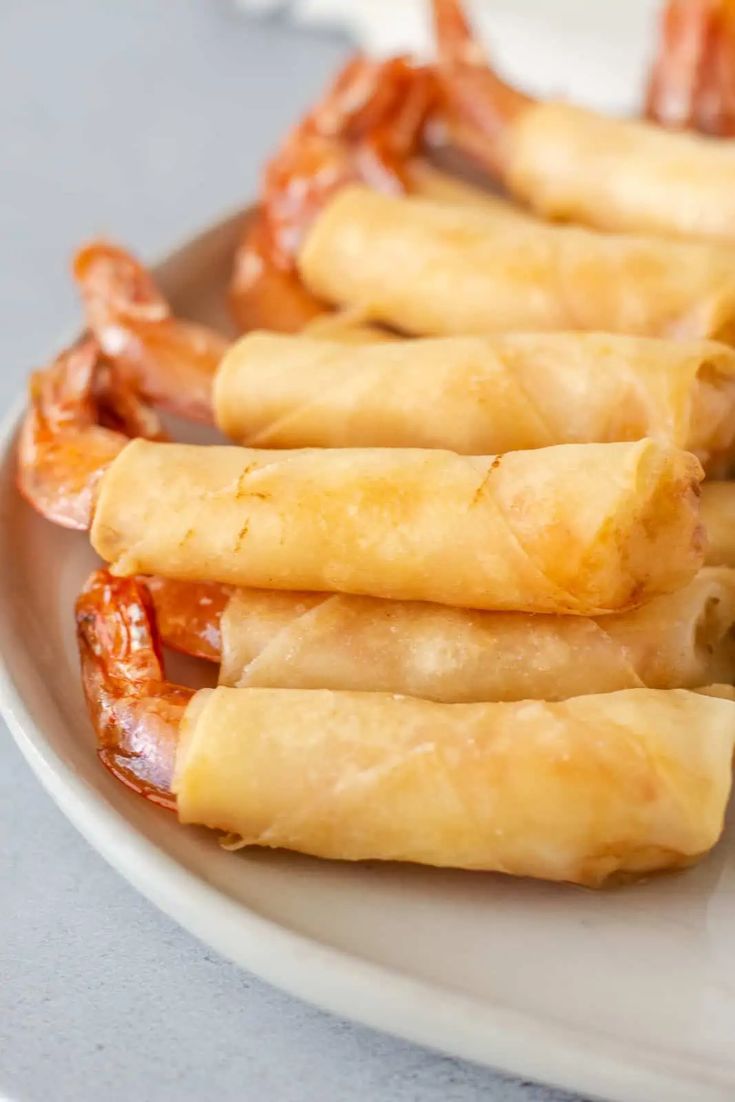 Fried Shrimp in a blanket stacked on a plate.