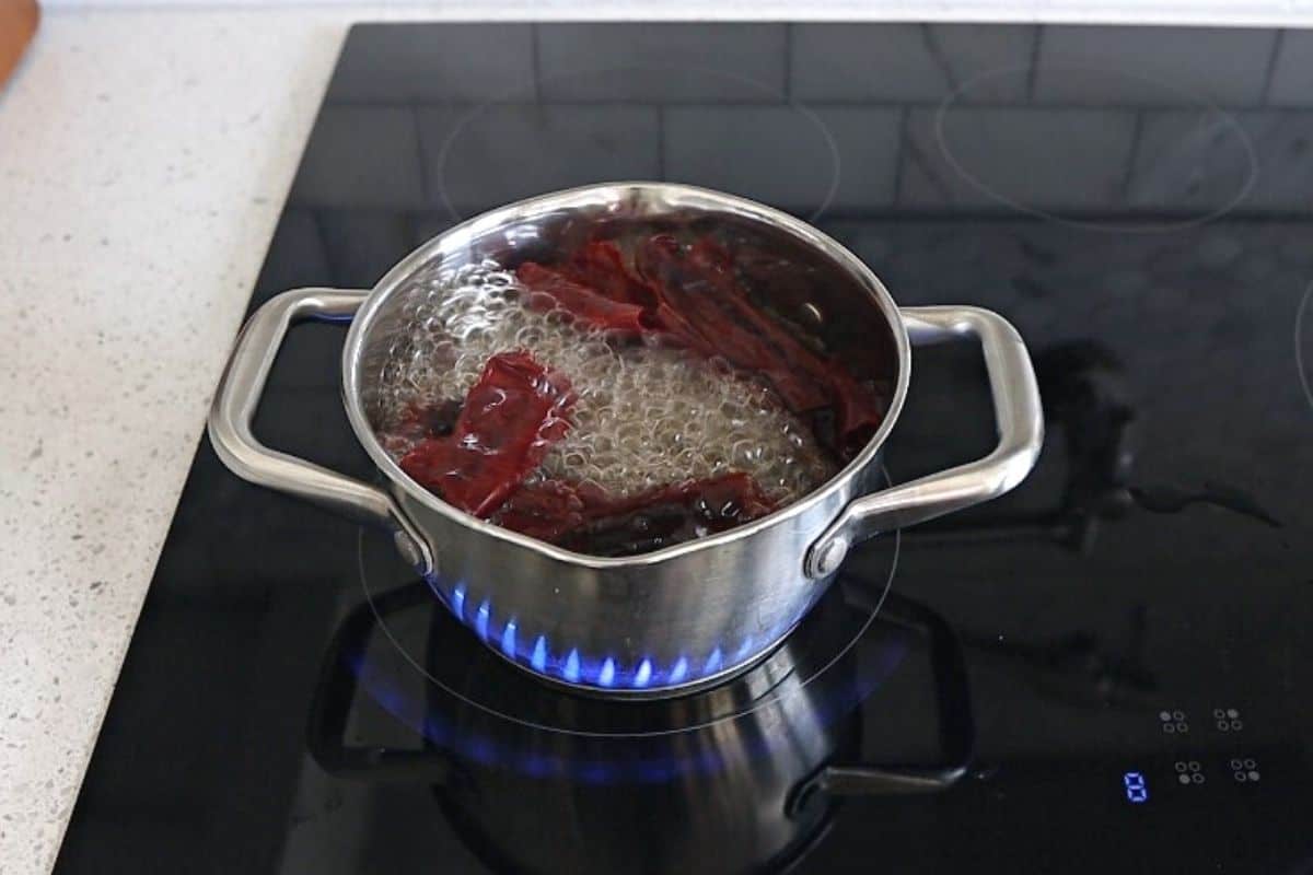 Chiles in a pot on the stove, boiling in water.