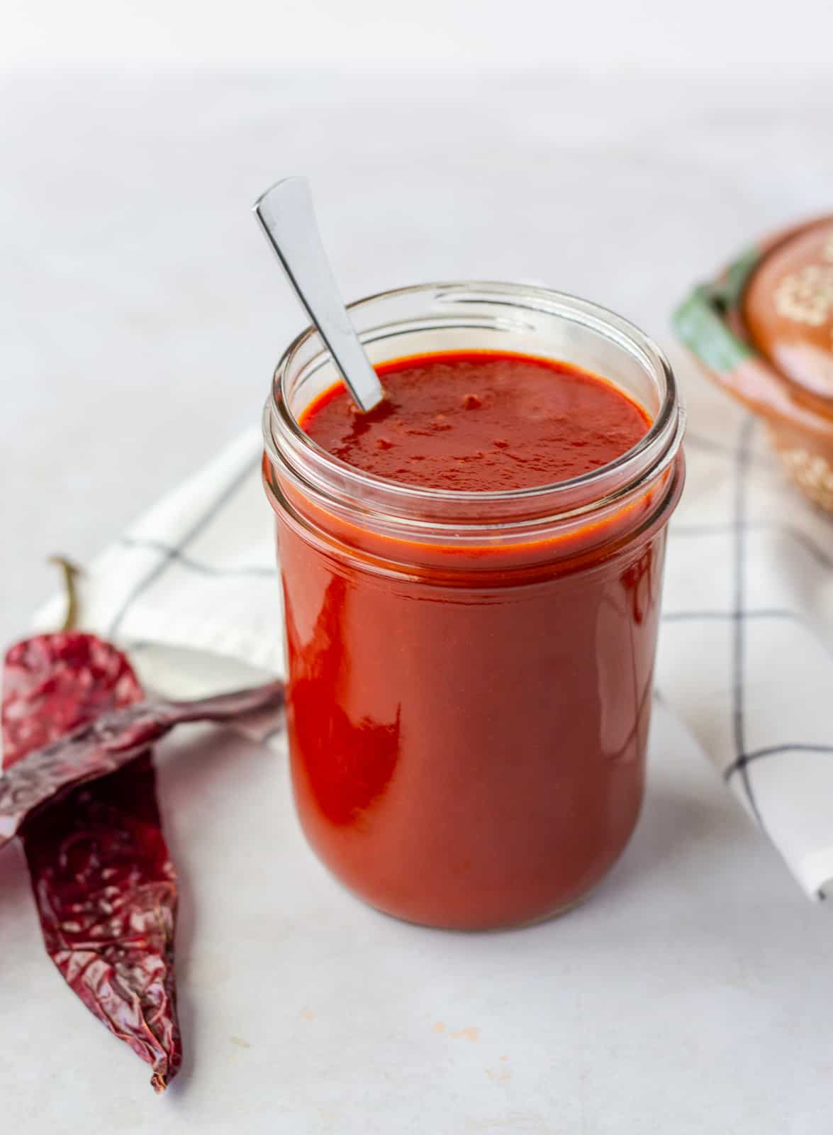 Enchilada Sauce in a mason jar with dried chiles on the side.