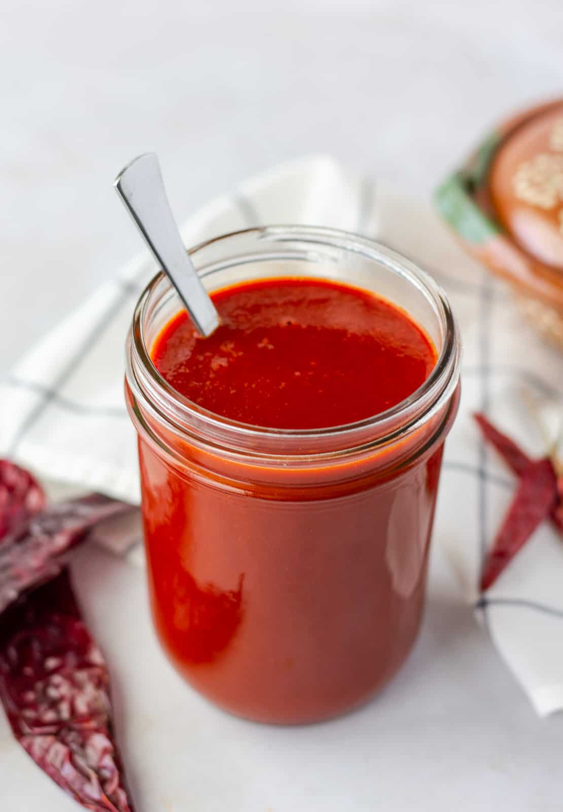 Up close view of enchilada sauce in a glass mason jar.