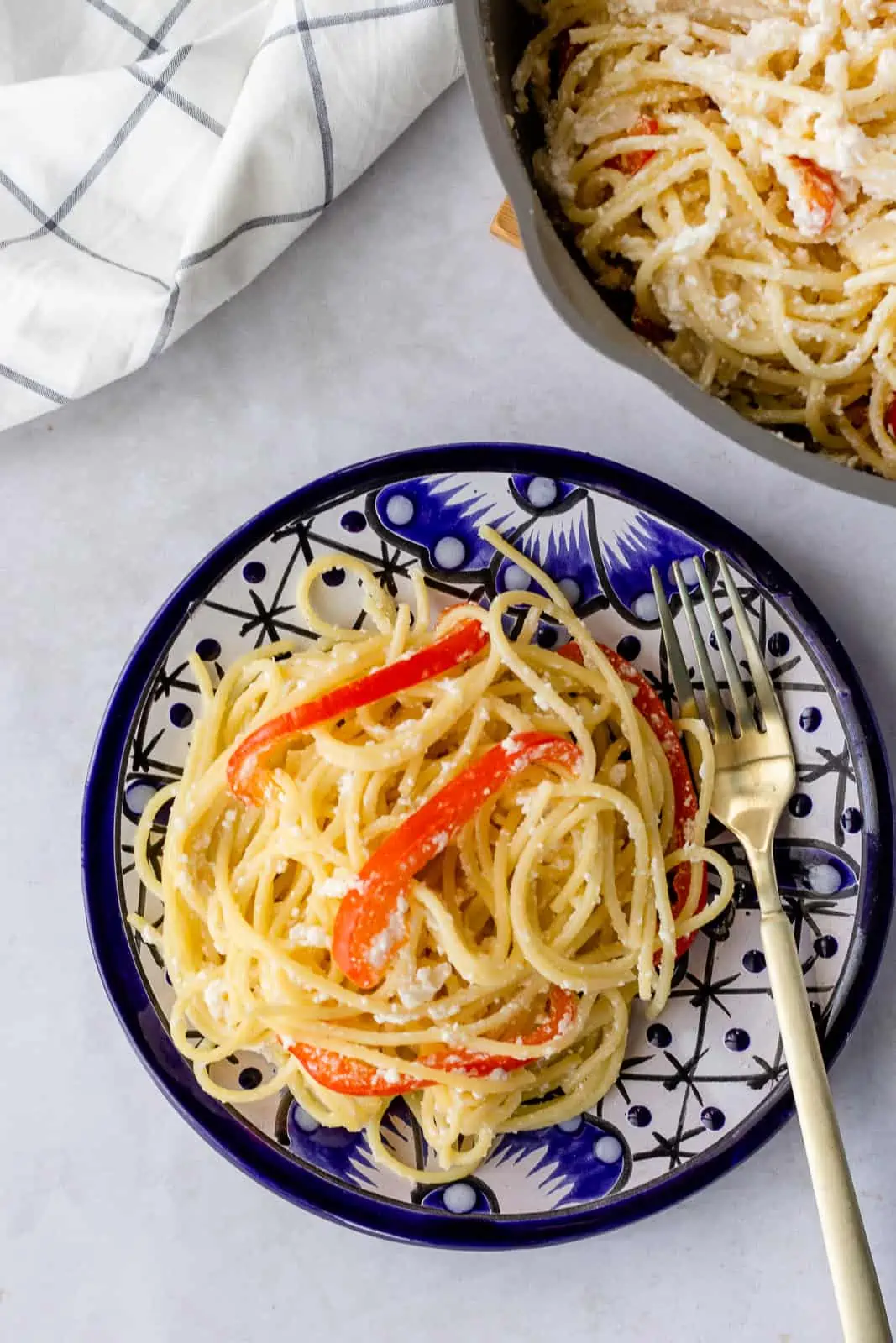 Overhead view of Espagueti Blanco on a plate and some in a sauté pan.