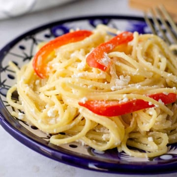 Up close view of spaghetti on a blue plate.