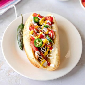 Feature image of Sonoran hot dog with toppings.