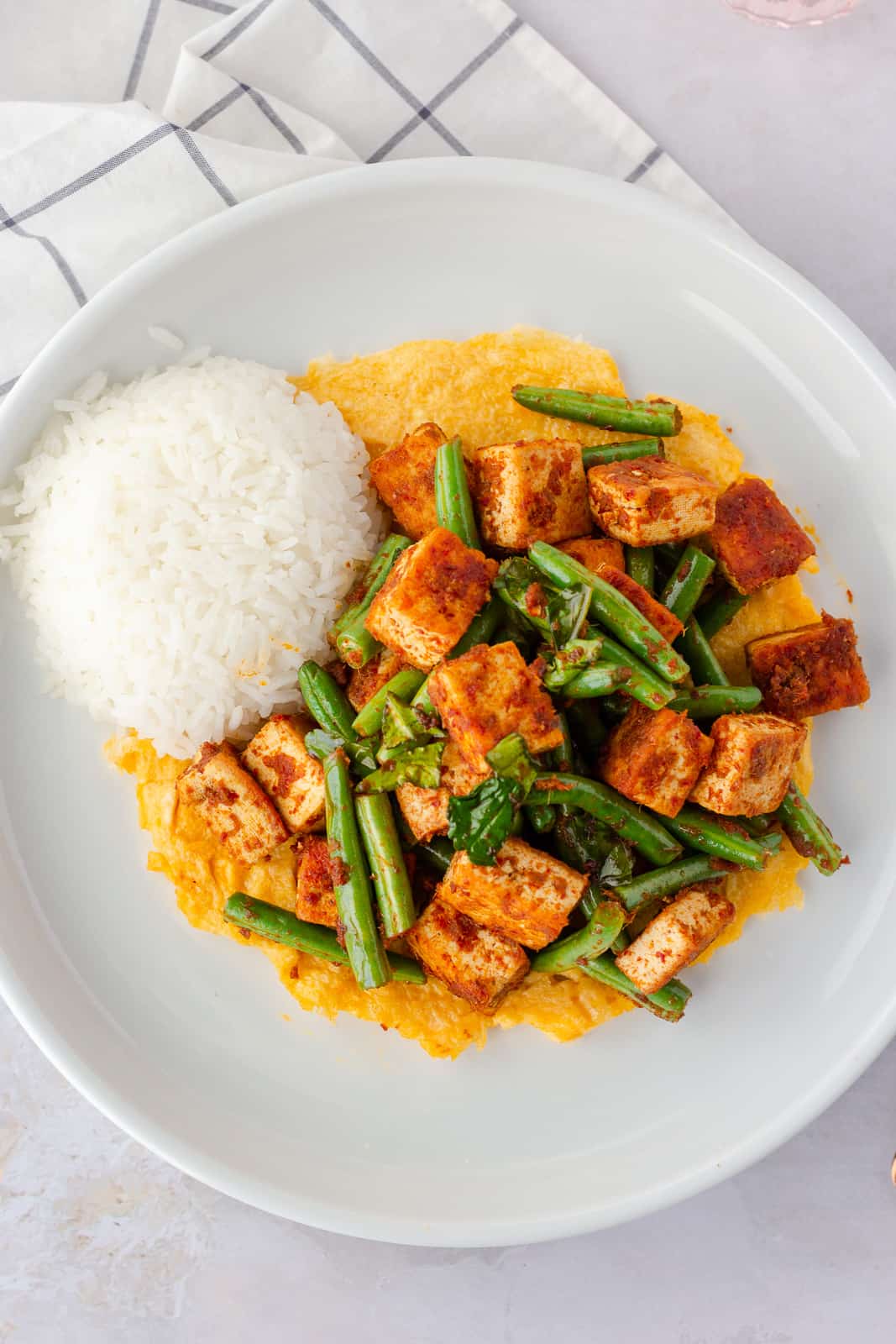 Overhead view of stir fry on a plate with rice and egg on the bottom.