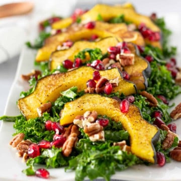 Feature image of roasted acorn squash salad topped with pomegranate seeds.