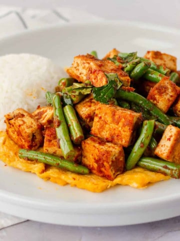 Feature image of pad prik tofu on a plate with rice.