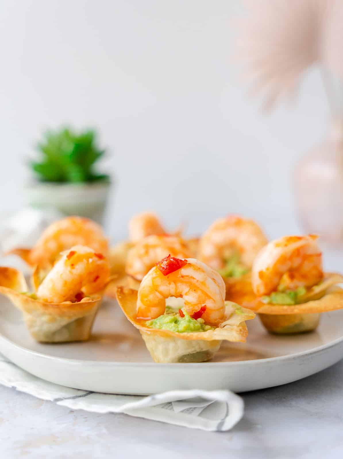 Shrimp and guacamole wonton cups on a plate.