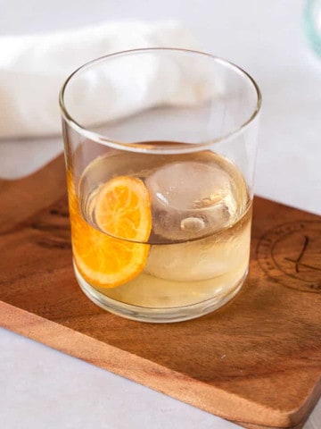 feature image of cocktail in a glass on a wood board.