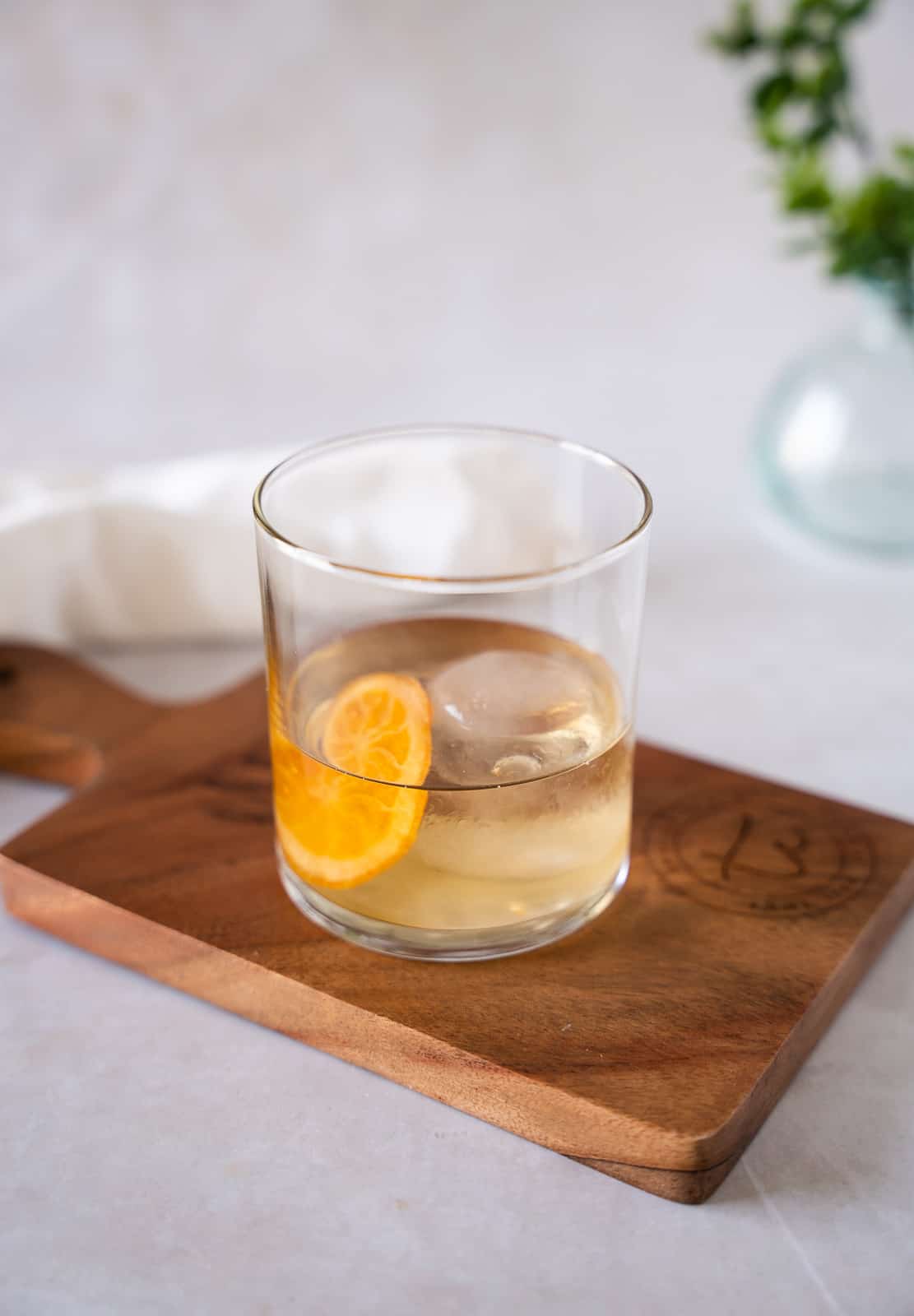 Cocktail in a glass on a wood board.