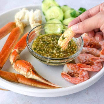 Feature image of crab being dipped into the seafood dipping sauce.
