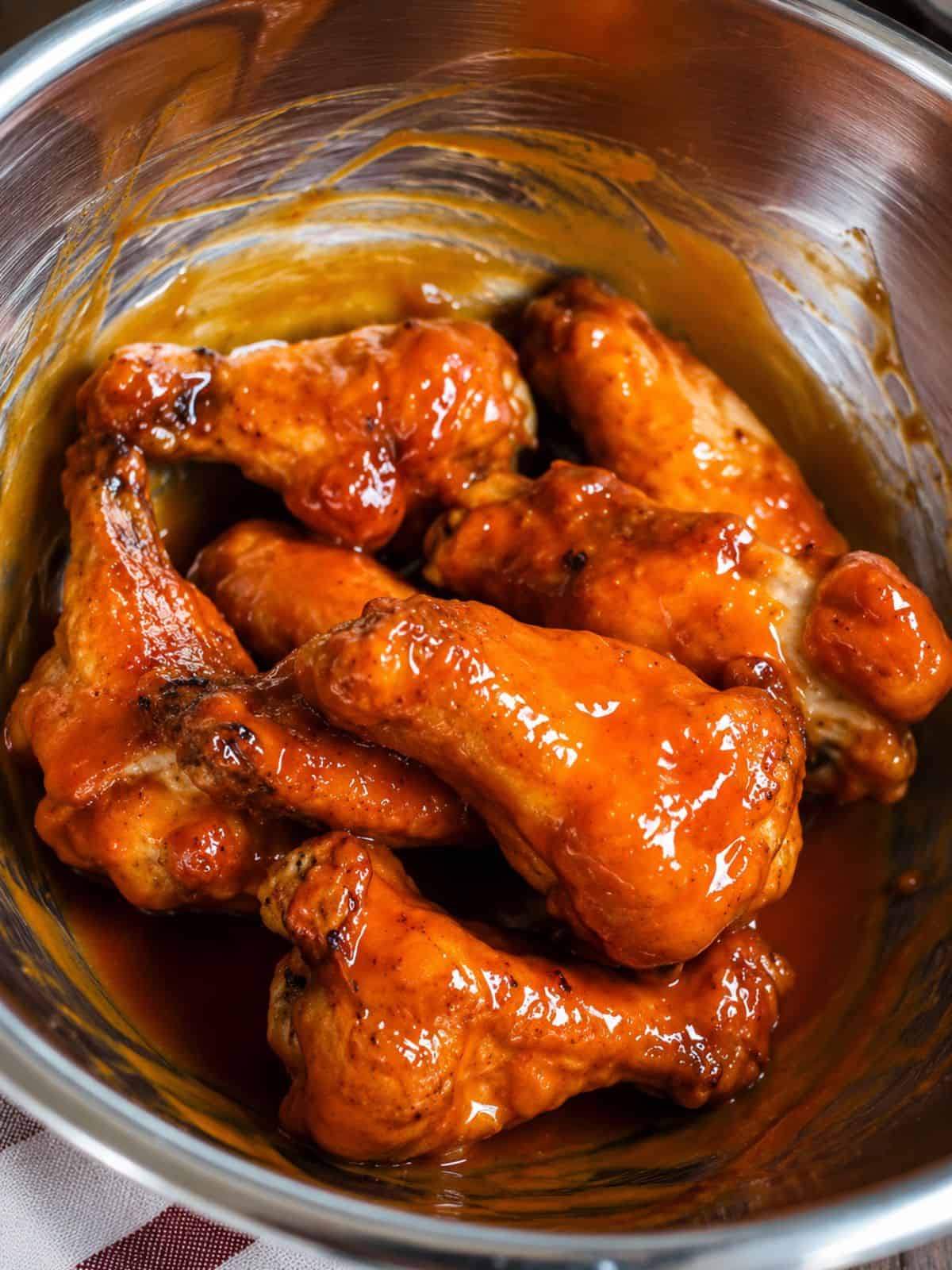 Chicken wings coated in sauce.