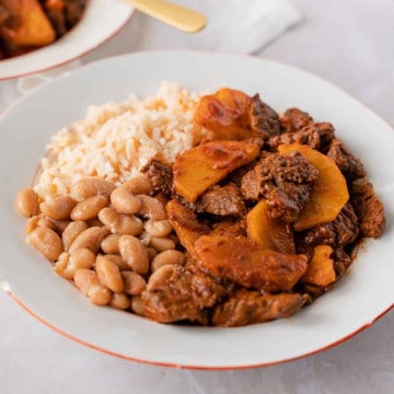Feature image of carne con papas with rice and beans.