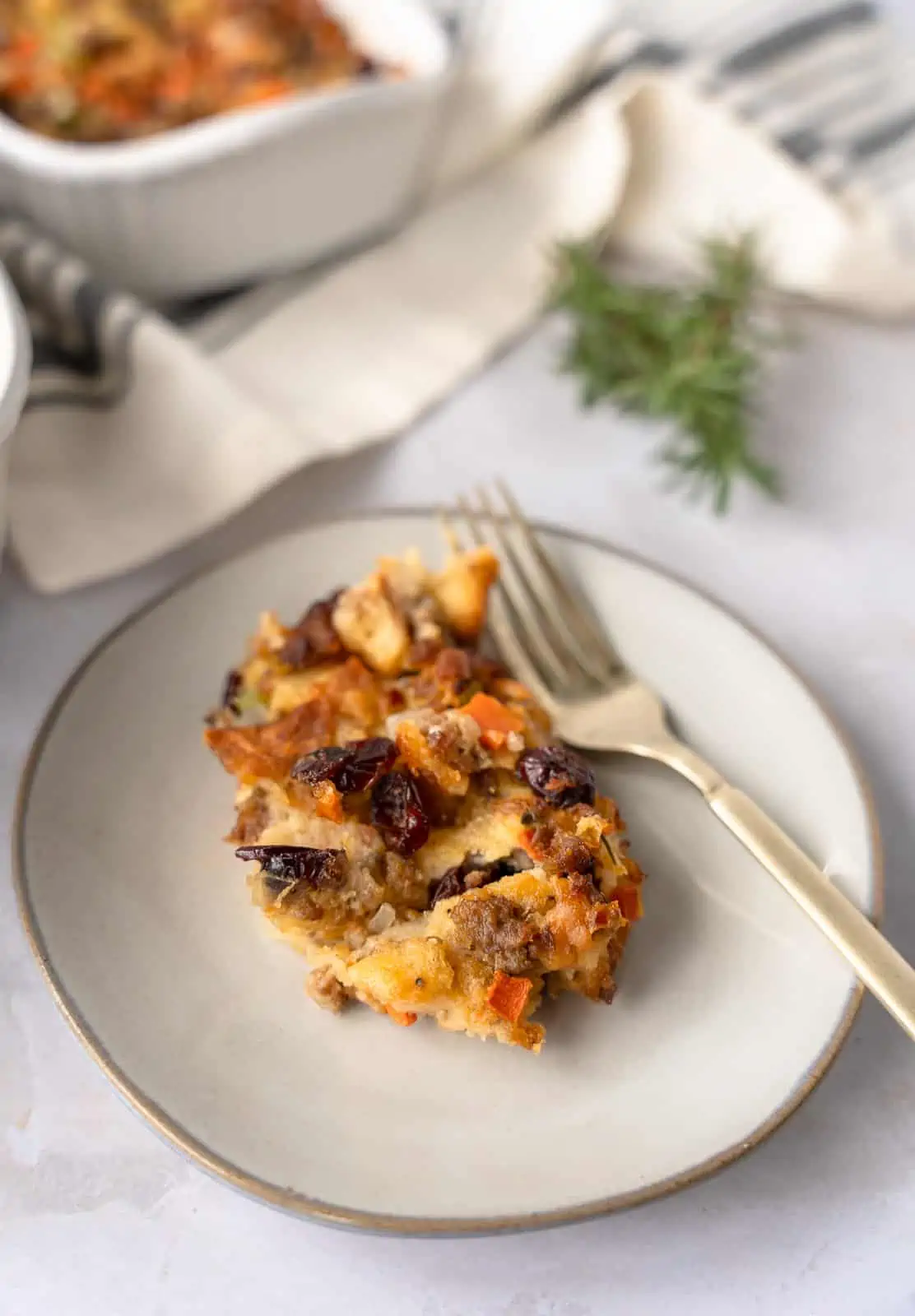 A portion of stuffing on a plate with a gold fork.