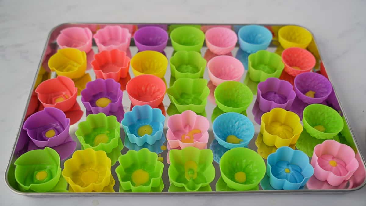 Empty flower silicon molds on a baking sheet.