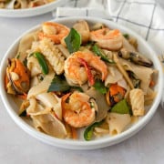 Feature image of pad kee mao with seafood on a plate.