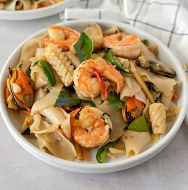 Feature image of pad kee mao with seafood on a plate.