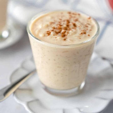 Feature image of arroz con leche in a glass cup.