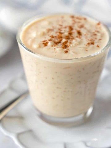 Feature image of arroz con leche in a glass cup.