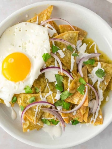 Feature image of chilaquiles verdes con huevo on a plate.
