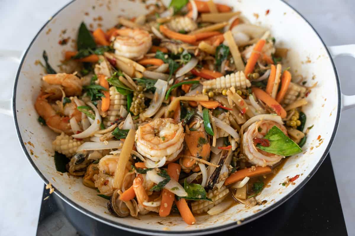 Completed stir fry in a large white skillet.