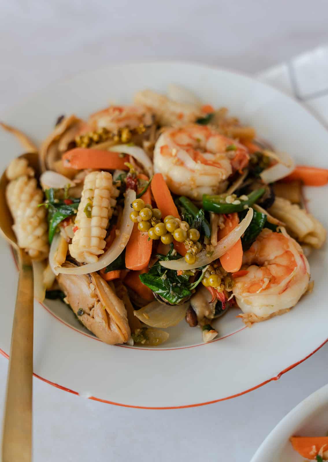 Pad cha talay in a plate with a gold spoon.