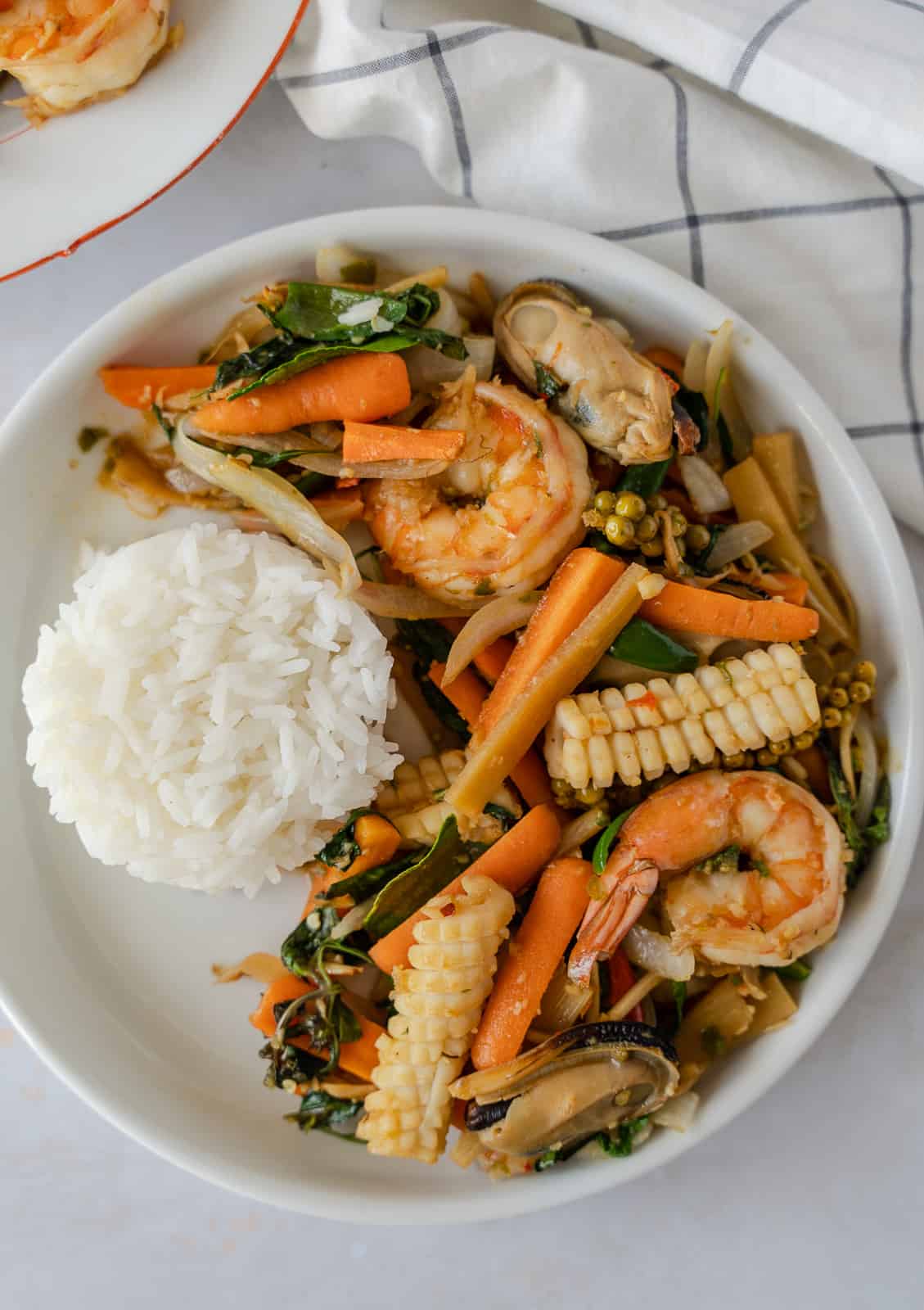 Overhead view of pad cha talay on a plate with a side of rice.