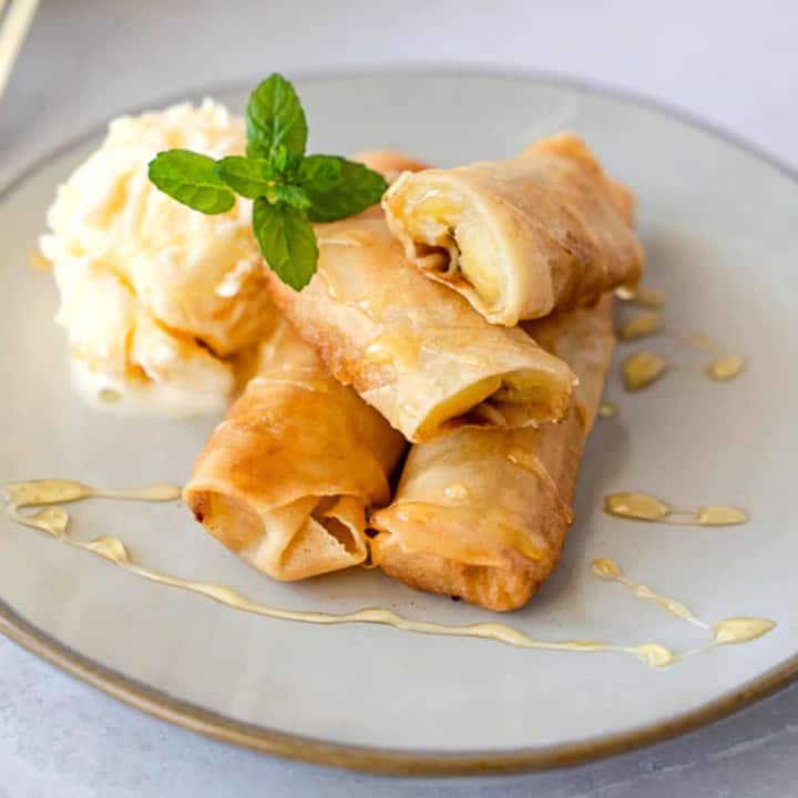 Feature image of fried banana spring rolls on a plate with ice cream.