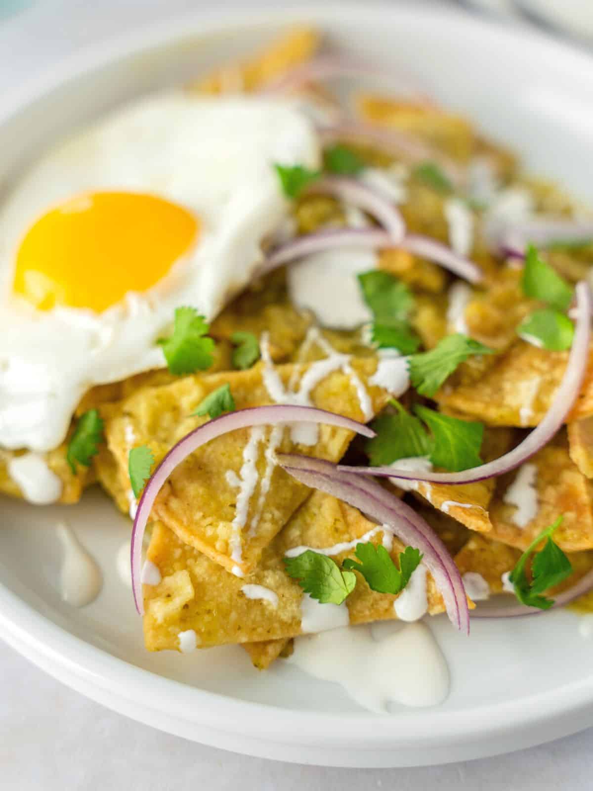 Chilaquiles verdes on a plate with a fried egg.